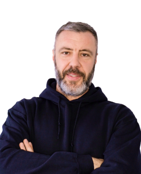 Mann mit Vollbart und kurzem Haar trägt schwarzen Kapuzenpullover und schaut freundlich