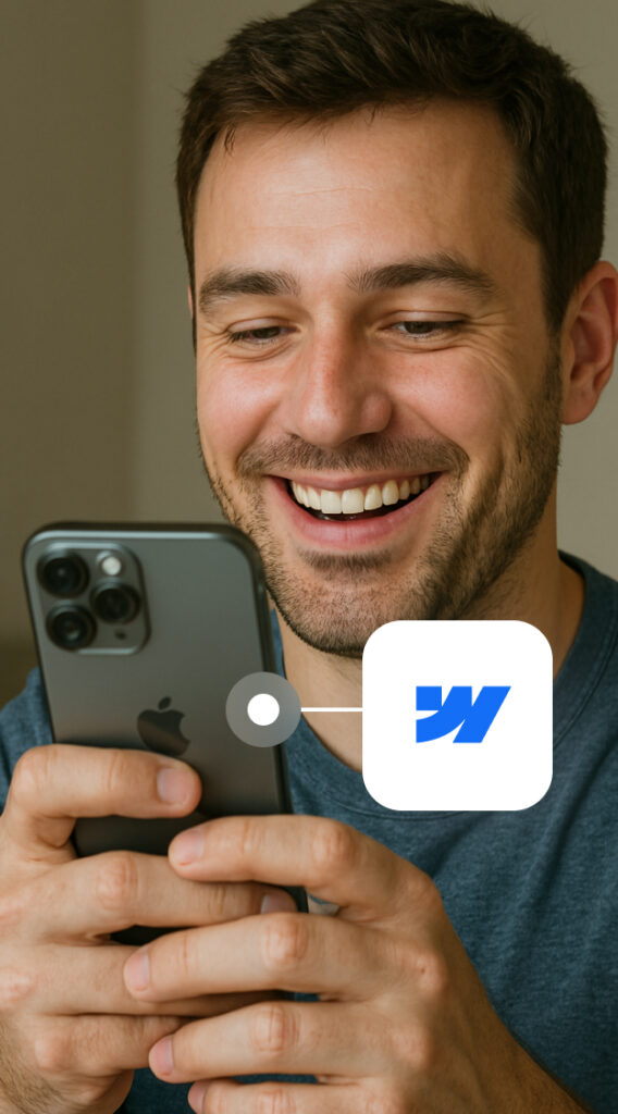 Mann lächelt beim Blick auf ein iPhone mit sichtbarkeitsbezogenem WalletConnect-Logo