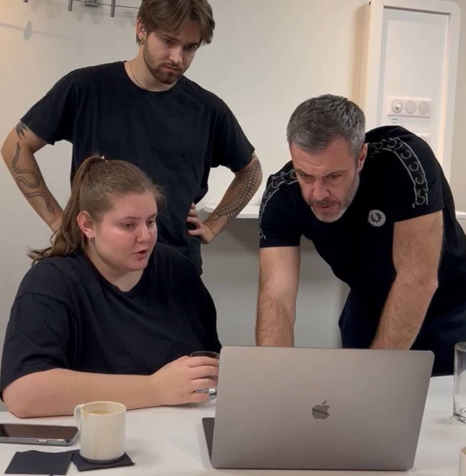 Design030 Mitarbeiter gucken auf den Laptop und diskutieren Ihre Arbeit.